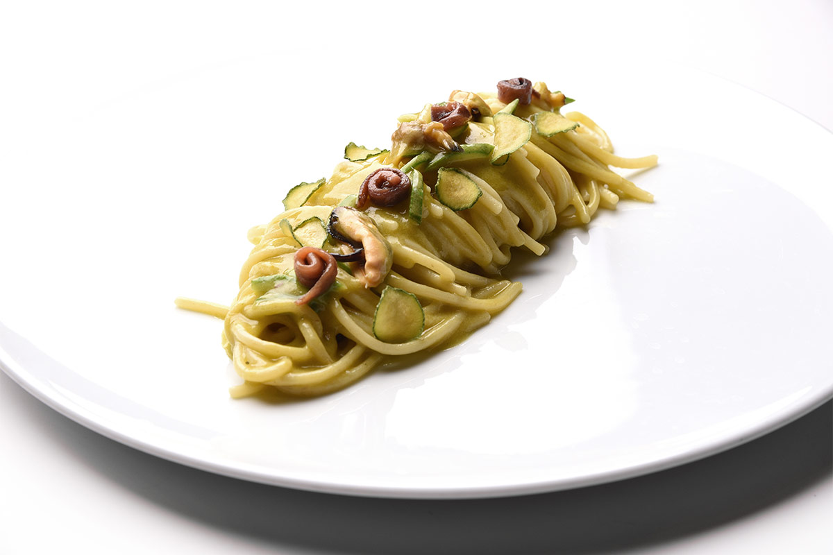 Spaghetti “Pastificio dei Campi”, pesto di fiori di zucca, alici del Cantabrico e molluschi Spaghetti pesto di fiori di zucca, alici del Cantabrico e molluschi