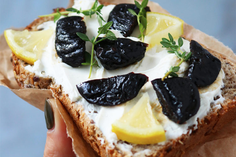 Toast integrale con formaggio spalmabile e prugne della California