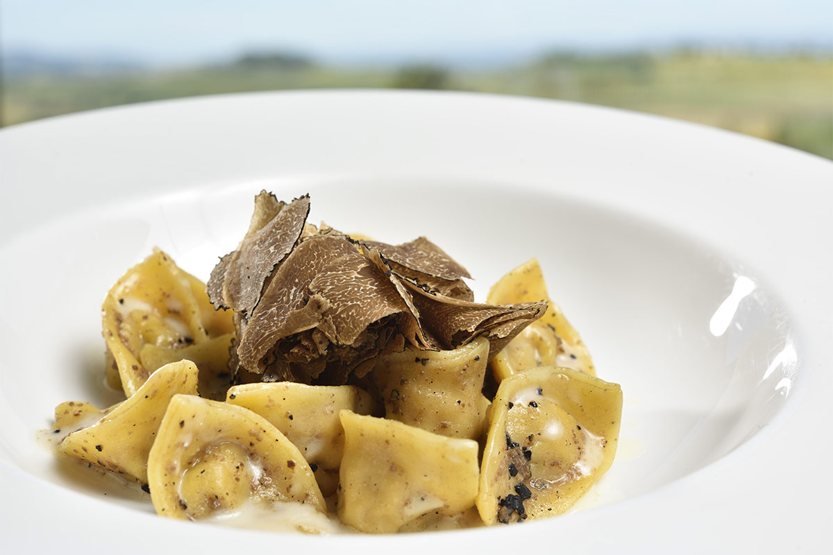 Cappellacci ripieni di prosciutto di Norcia su fonduta di Parmigiano e tartufo uncinato Cappellacci ripieni di prosciutto di Norcia su fonduta di Parmigiano e tartufo uncinato