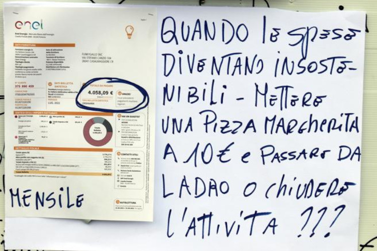 Il cartello esposto sulla vetrina della pizzeria Funky Gallo Bar e ristoranti, bollette in vetrina per protestare contro i rincari