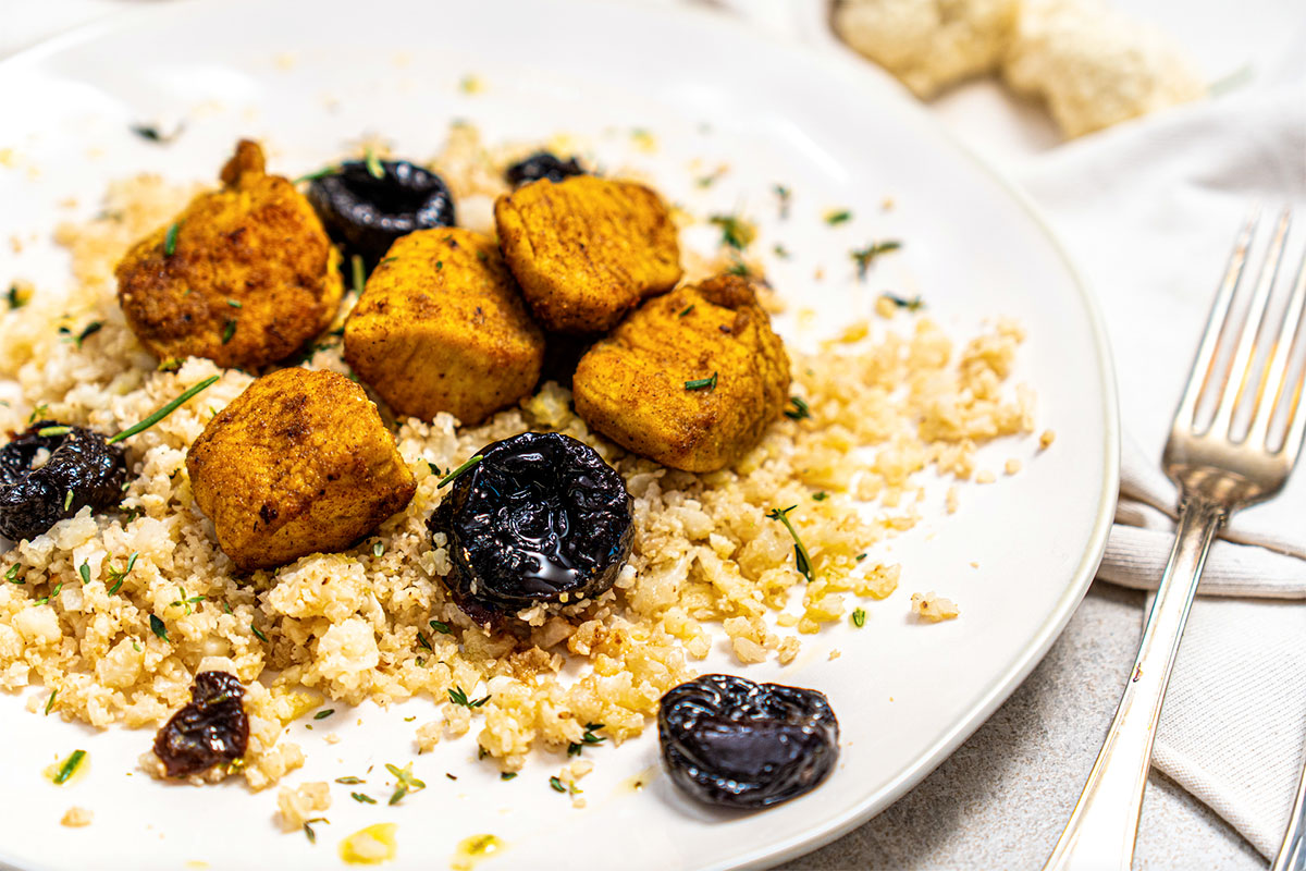 Riso di cavolfiore tostato con bocconcini di pollo al curry, Prugne della California ed erbe aromatiche Riso di cavolfiore tostato con bocconcini di pollo al curry, Prugne della California ed erbe aromatiche